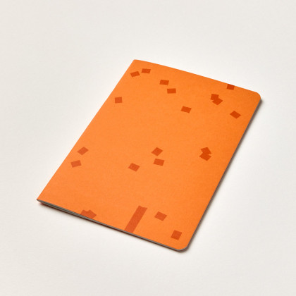 oranžový sešit A5 s tmavšími drobnými čtverečky na obálce
